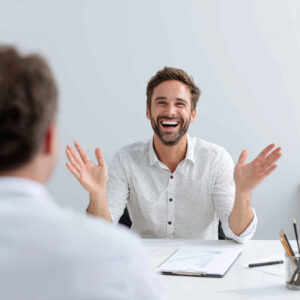 Homme en entretien d’embauche exprimant enthousiasme et engagement par sa posture corporelle.